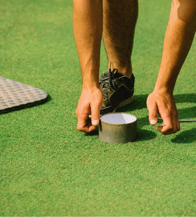 man fixing golf hole